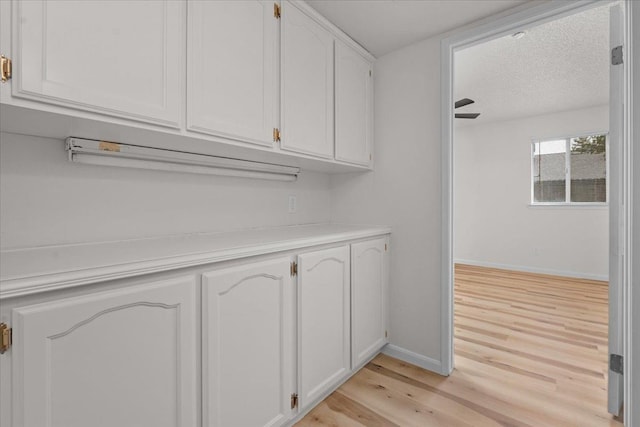 interior space featuring a textured ceiling, baseboards, and wood finished floors