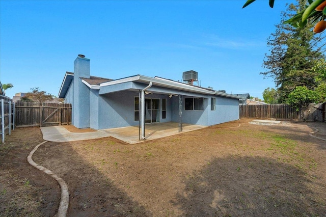 back of property featuring a patio area, a fenced backyard, a chimney, and stucco siding