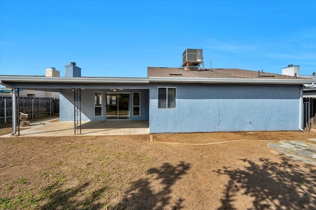 rear view of house with central air condition unit, a patio area, fence, and stucco siding