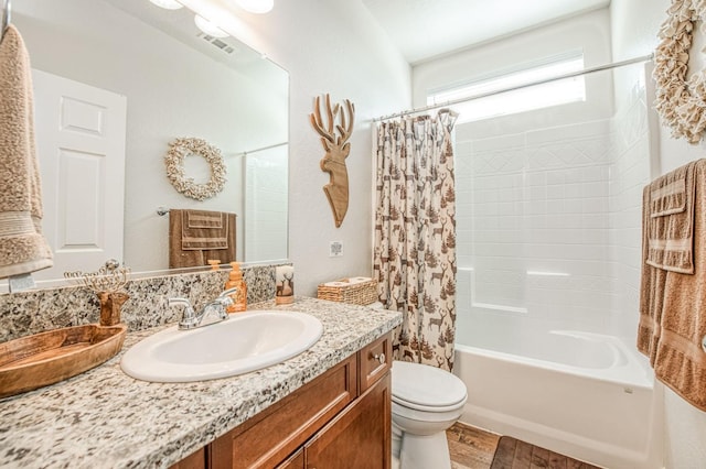 full bathroom with toilet, wood finished floors, vanity, visible vents, and shower / bath combination with curtain