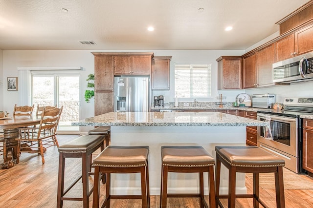 36105 Cressman Rd, Shaver Lake, CA 93664 - kitchen featuring appliances with stainless steel finishes, a kitchen breakfast bar, a kitchen island, healthy amount of natural light, and recessed lighting