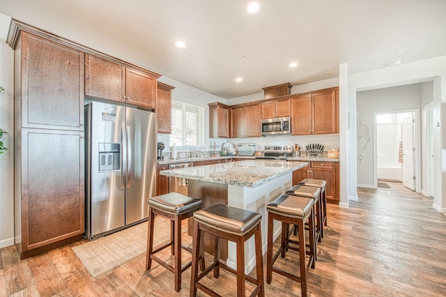 36105 Cressman Rd, Shaver Lake, CA 93664 - kitchen featuring appliances with stainless steel finishes, a kitchen island, a kitchen bar, light wood-style floors, and recessed lighting