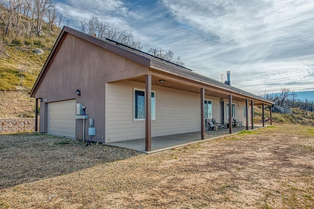 view of home's exterior featuring driveway and a patio