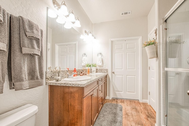 36105 Cressman Rd, Shaver Lake, CA 93664 - full bath with toilet, wood finished floors, double vanity, a stall shower, and a textured wall