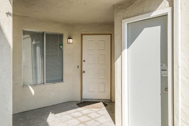 entrance to property with stucco siding