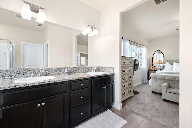 ensuite bathroom with double vanity, ensuite bath, tile patterned flooring, and a sink