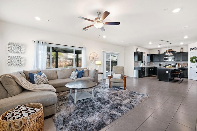 tiled living room with recessed lighting, visible vents, ceiling fan, and a sink