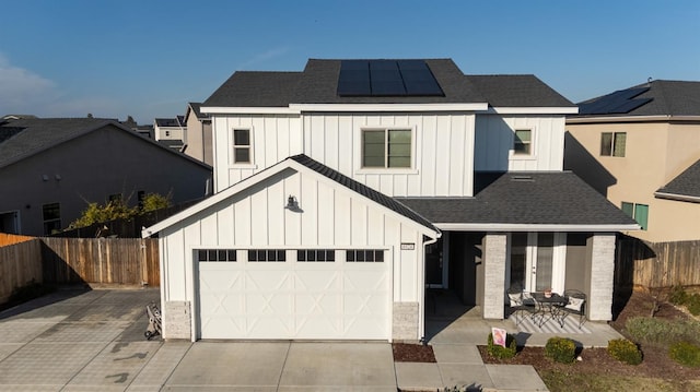 modern farmhouse featuring driveway, board and batten siding, and solar panels