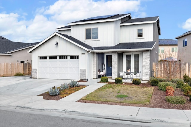 modern farmhouse style home featuring covered porch, solar panels, board and batten siding, and concrete driveway