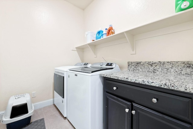 washroom with cabinet space, baseboards, washer and dryer, and light tile patterned flooring