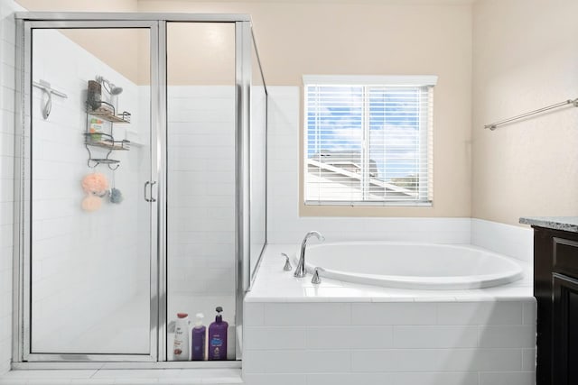 full bathroom with a stall shower, a garden tub, and vanity