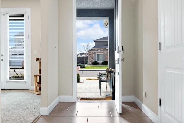 tiled entryway featuring baseboards