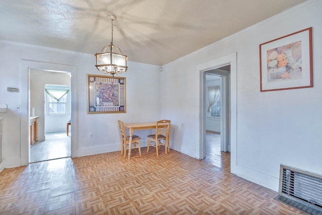 dining room featuring ornamental molding, an inviting chandelier, visible vents, and baseboards