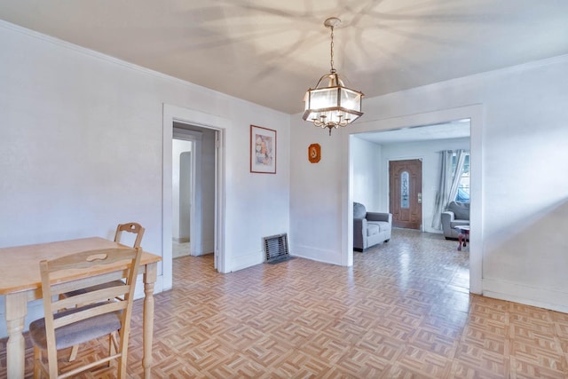 dining area with visible vents, baseboards, a notable chandelier, and ornamental molding