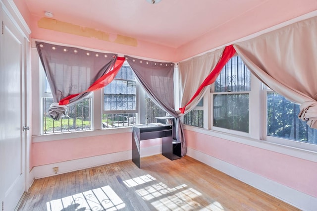 additional living space featuring hardwood / wood-style floors and baseboards