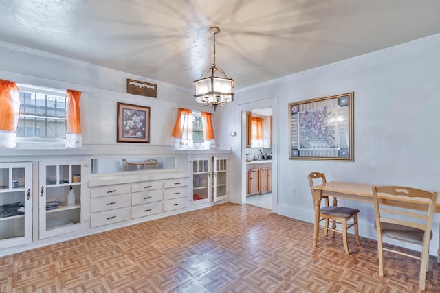 dining room with baseboards, a chandelier, and crown molding