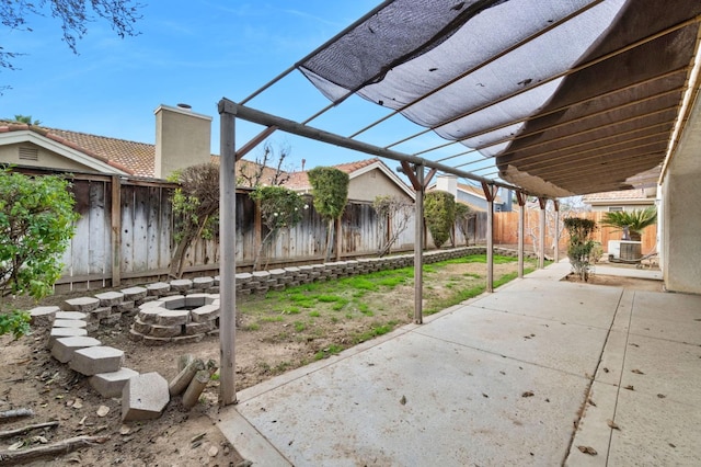 view of patio featuring a fire pit, a fenced backyard, cooling unit, and a pergola