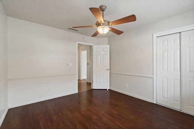 unfurnished bedroom with wood finished floors, a closet, baseboards, visible vents, and a textured ceiling