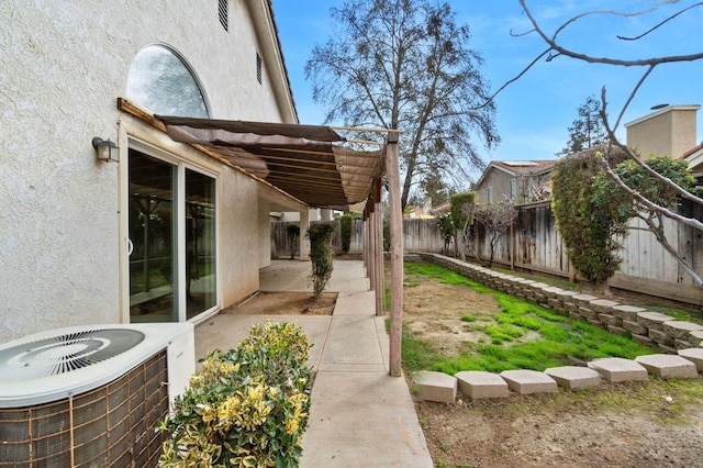 view of yard with a fenced backyard, a patio, and central air condition unit