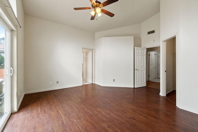 unfurnished bedroom featuring high vaulted ceiling, dark wood-style flooring, a ceiling fan, visible vents, and baseboards