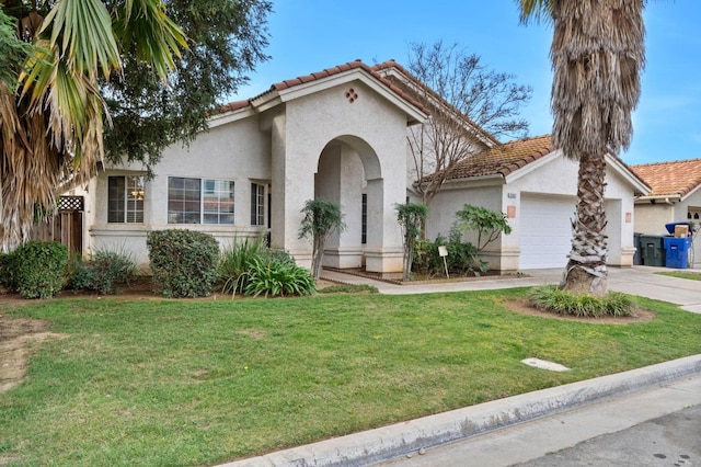 mediterranean / spanish house with a garage, concrete driveway, a tiled roof, a front lawn, and stucco siding