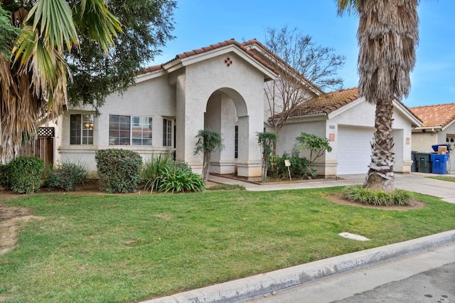 mediterranean / spanish-style home featuring a front yard, stucco siding, a tile roof, and an attached garage