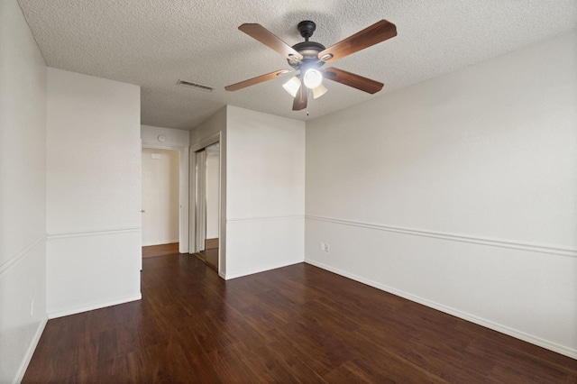 spare room featuring visible vents, ceiling fan, a textured ceiling, wood finished floors, and baseboards