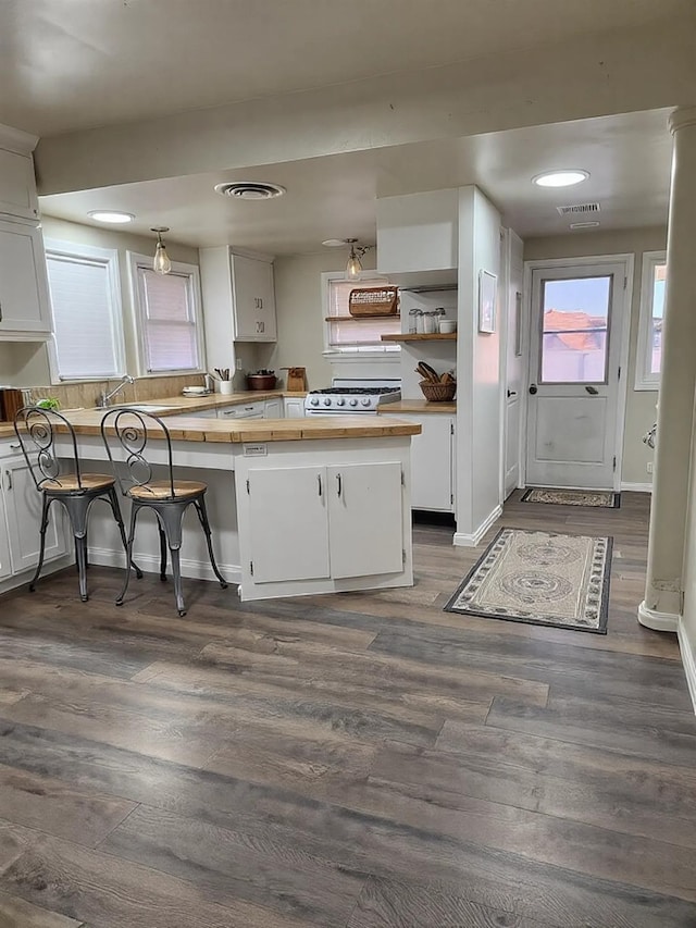 kitchen featuring dark wood-style floors, visible vents, wood counters, and white cabinetry