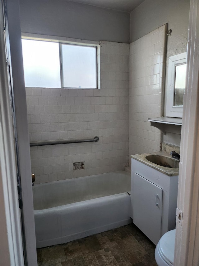 full bathroom featuring stone finish floor, vanity, and toilet