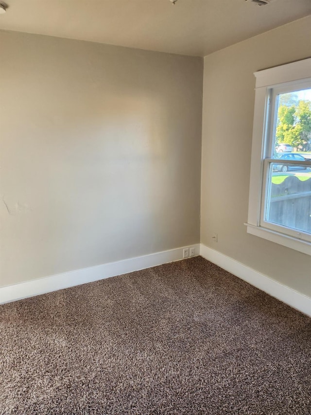 carpeted empty room with baseboards