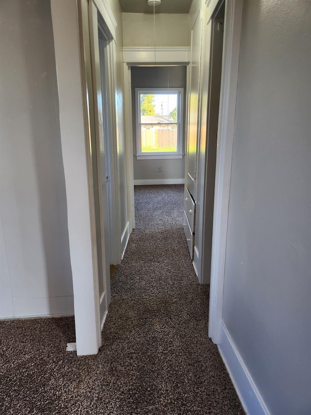 corridor with carpet and baseboards