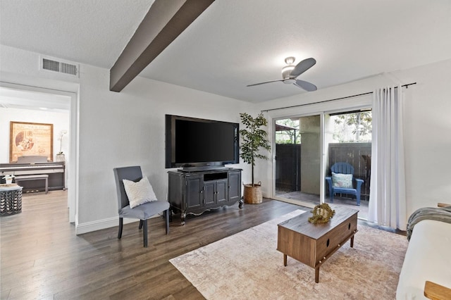 living area featuring ceiling fan, wood finished floors, visible vents, baseboards, and beamed ceiling