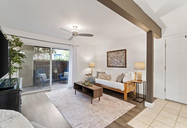 living area featuring light wood-style floors, baseboards, and a ceiling fan