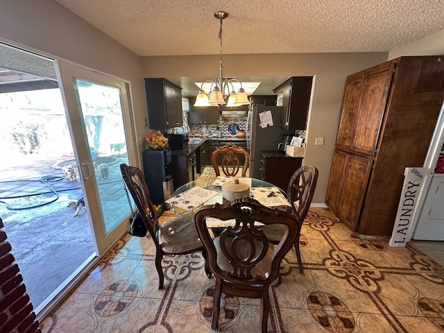 dining room with an inviting chandelier, light tile patterned floors, and a textured ceiling