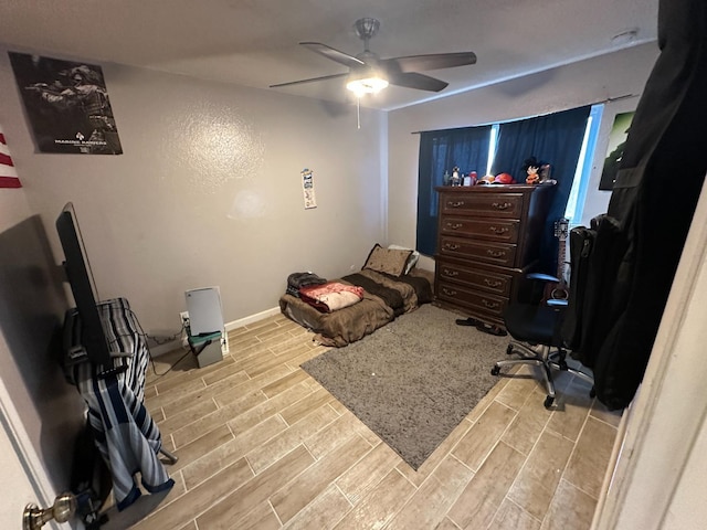 bedroom featuring wood finish floors, ceiling fan, and baseboards