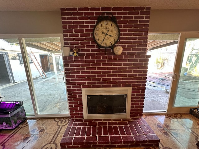 interior space with a brick fireplace and a textured ceiling