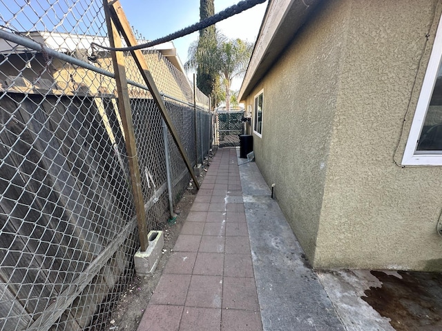 view of side of home featuring fence and stucco siding