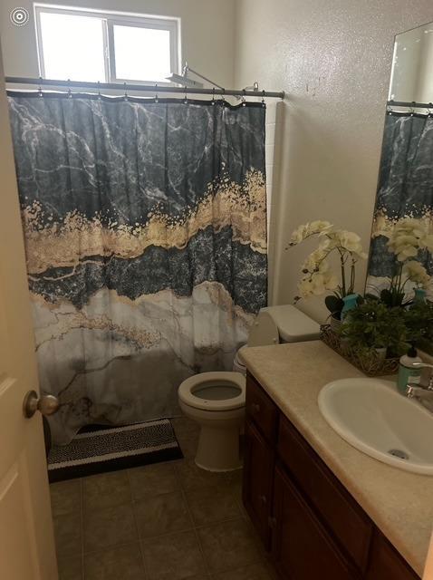 bathroom featuring vanity, tile patterned flooring, toilet, and a shower with curtain