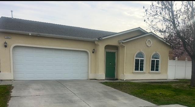 view of front of house with an attached garage, fence, concrete driveway, and stucco siding