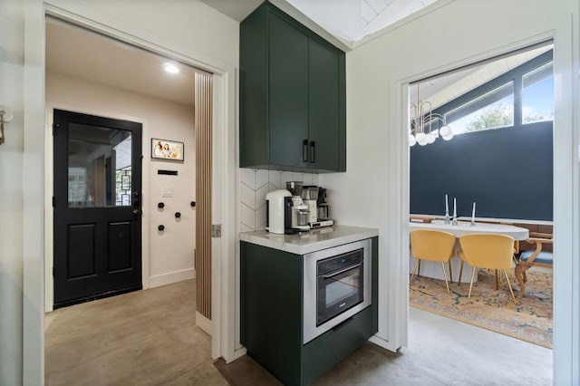 2460 W Browning Ave, Fresno, CA 93711 - kitchen with a notable chandelier, baseboards, light countertops, backsplash, and green cabinetry
