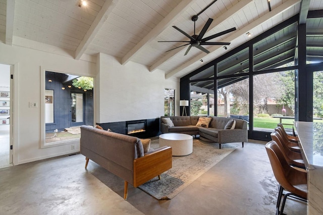 living room featuring high vaulted ceiling, beamed ceiling, concrete flooring, and a tile fireplace