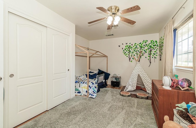 bedroom with a ceiling fan, a closet, visible vents, and carpet flooring