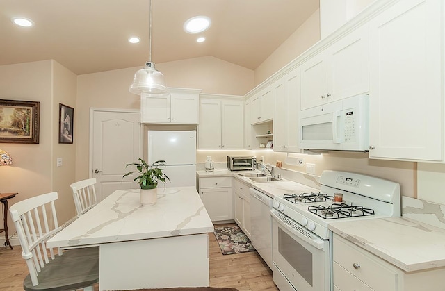 kitchen with white appliances, lofted ceiling, a kitchen island, light wood-type flooring, and a sink