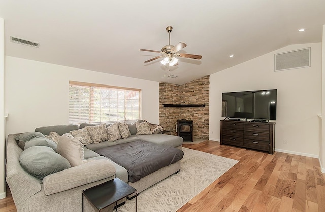 living area featuring vaulted ceiling, light wood-style flooring, visible vents, and a ceiling fan