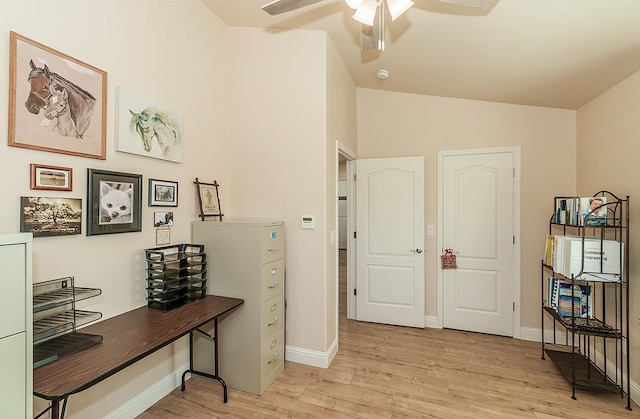 home office featuring vaulted ceiling, light wood finished floors, a ceiling fan, and baseboards