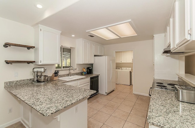 kitchen with a peninsula, a sink, black dishwasher, independent washer and dryer, and freestanding refrigerator