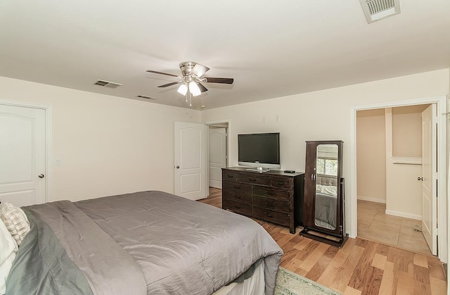 bedroom with a ceiling fan, visible vents, and light wood-style flooring