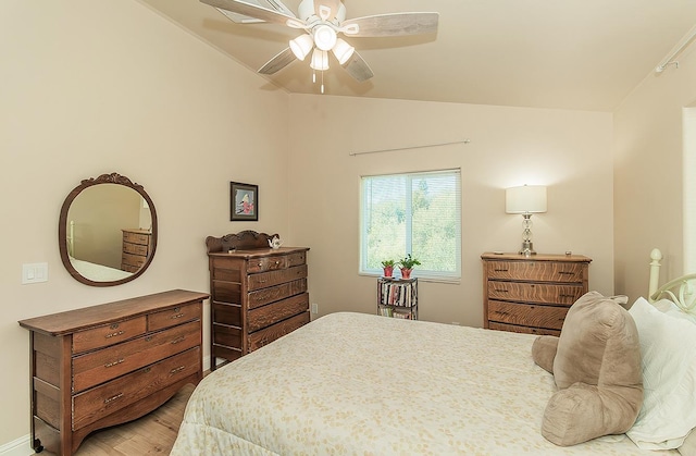 bedroom featuring vaulted ceiling, light wood finished floors, and ceiling fan