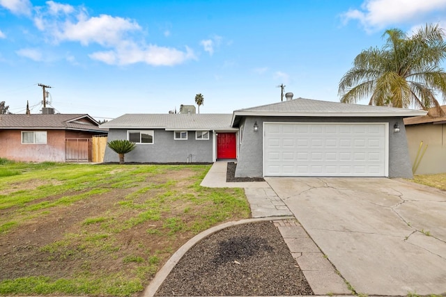 ranch-style house with stucco siding, concrete driveway, an attached garage, fence, and a front lawn