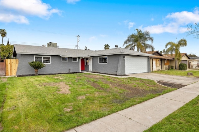 ranch-style home with concrete driveway, a front lawn, an attached garage, and fence